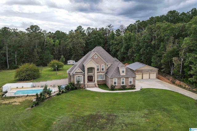 view of front facade with a front lawn, a fenced in pool, and a garage