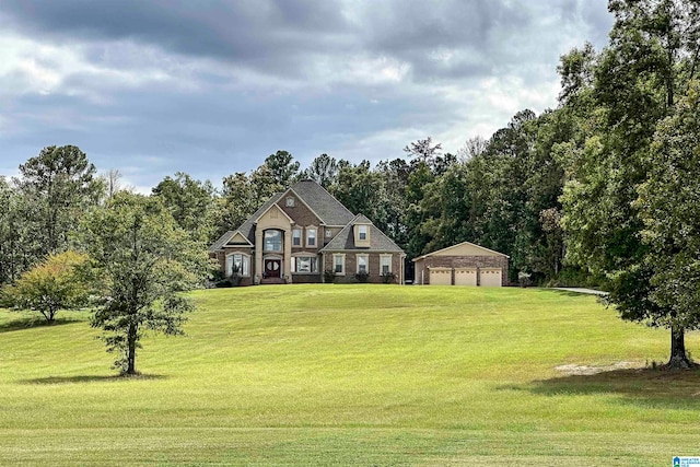 view of front of home with a garage, a front lawn, and an outbuilding