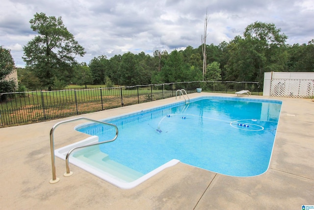 view of pool with a diving board and a patio