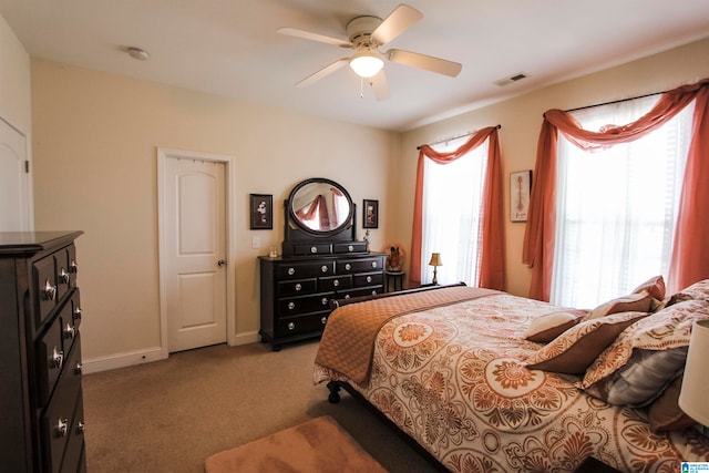 carpeted bedroom featuring ceiling fan and multiple windows