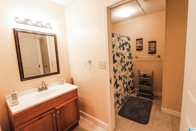 bathroom featuring vanity, a paneled ceiling, and tile patterned flooring