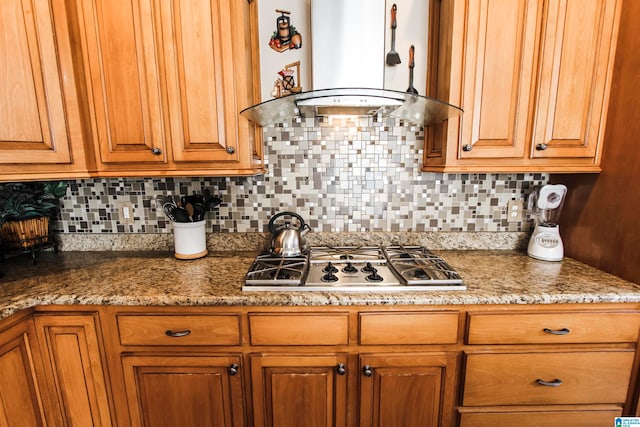 kitchen featuring island range hood, decorative backsplash, stainless steel gas stovetop, and stone counters