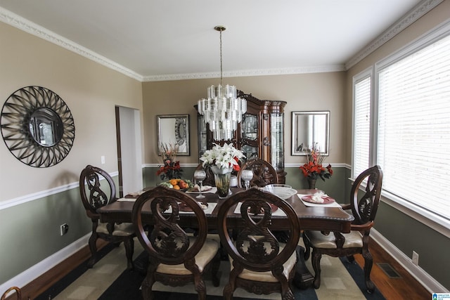 dining room with ornamental molding, visible vents, a chandelier, wood finished floors, and baseboards