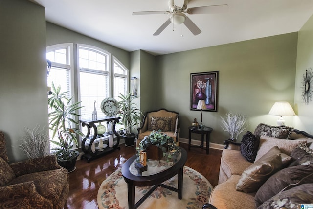 living room featuring baseboards, a ceiling fan, and wood finished floors