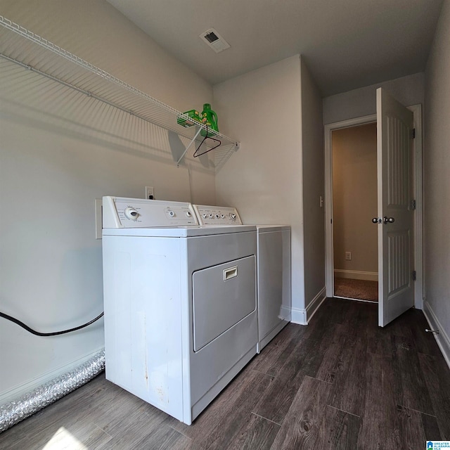 laundry area with dark hardwood / wood-style flooring and washing machine and dryer