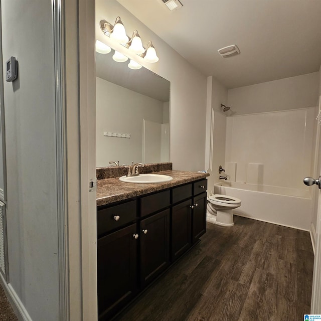 full bathroom with  shower combination, hardwood / wood-style flooring, vanity, and toilet