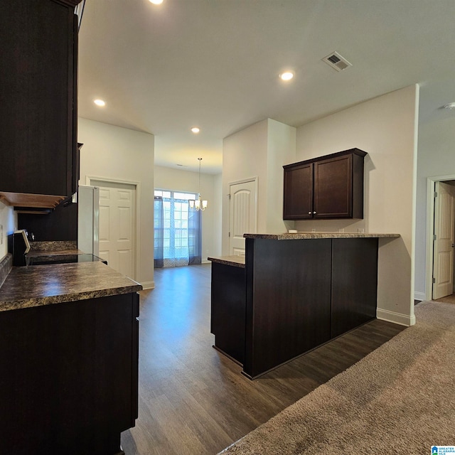 kitchen featuring dark brown cabinetry, fridge, a notable chandelier, and dark hardwood / wood-style flooring