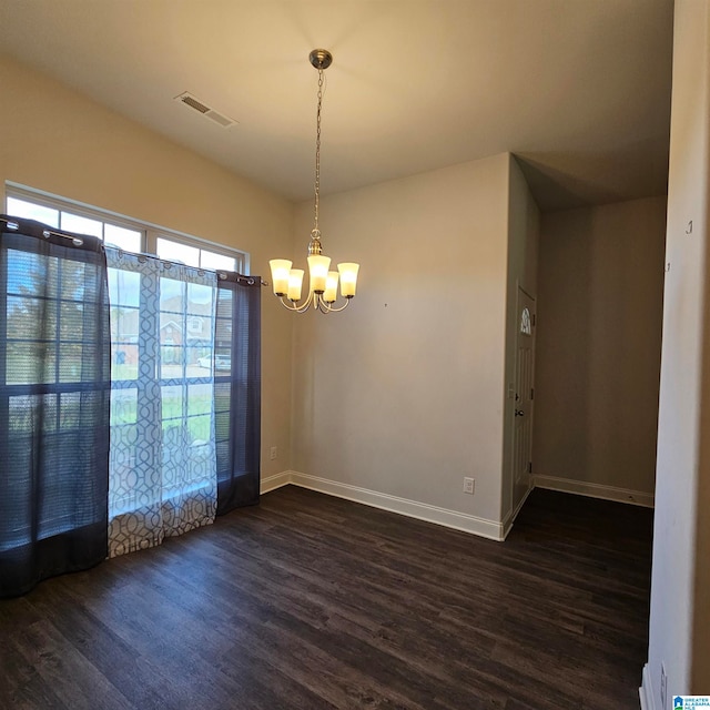 unfurnished room with a chandelier and dark hardwood / wood-style flooring