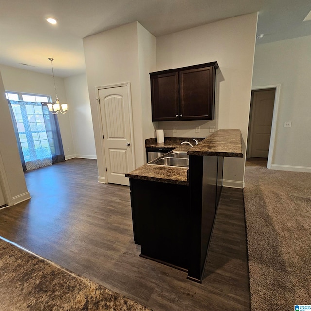 kitchen with a notable chandelier, pendant lighting, sink, and dark hardwood / wood-style flooring