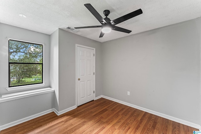 unfurnished bedroom featuring ceiling fan, hardwood / wood-style flooring, and a textured ceiling