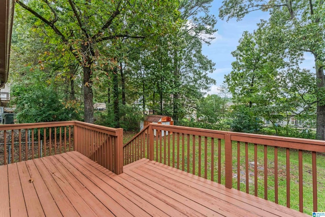 deck featuring a lawn and a storage unit