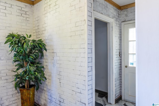 interior space featuring brick wall and crown molding