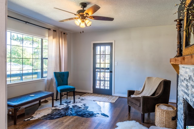 living area with a fireplace, dark hardwood / wood-style floors, and a healthy amount of sunlight