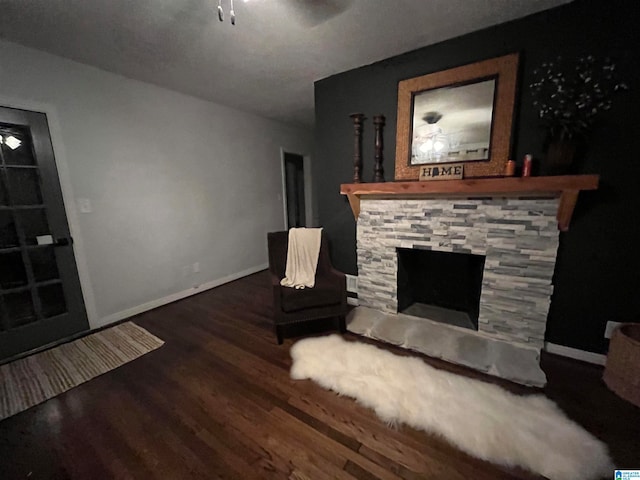 living room with a fireplace, dark hardwood / wood-style floors, and ceiling fan