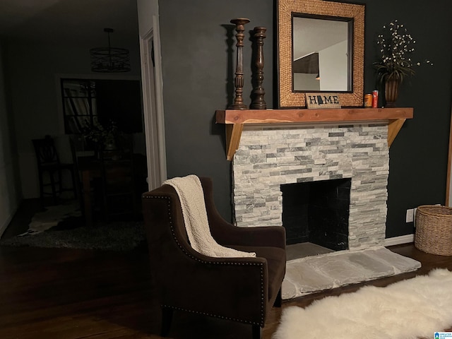 living area featuring hardwood / wood-style flooring and a stone fireplace