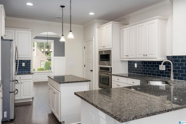 kitchen with a center island, white cabinets, sink, dark stone countertops, and stainless steel appliances