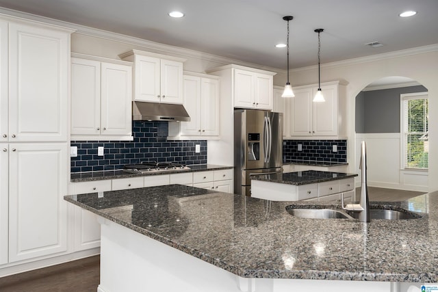 kitchen featuring white cabinetry, dark stone countertops, a kitchen island with sink, and appliances with stainless steel finishes