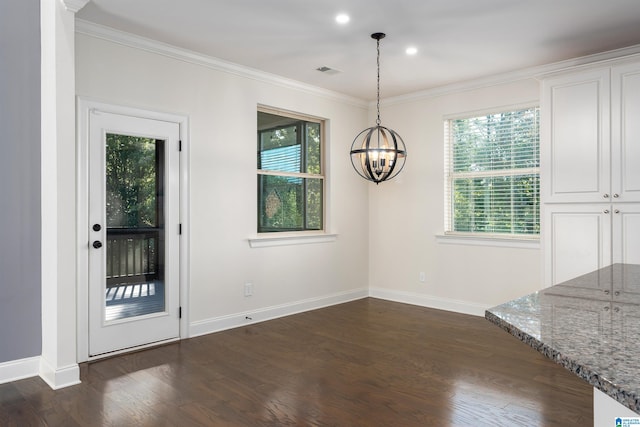 unfurnished dining area with an inviting chandelier, dark hardwood / wood-style floors, and ornamental molding