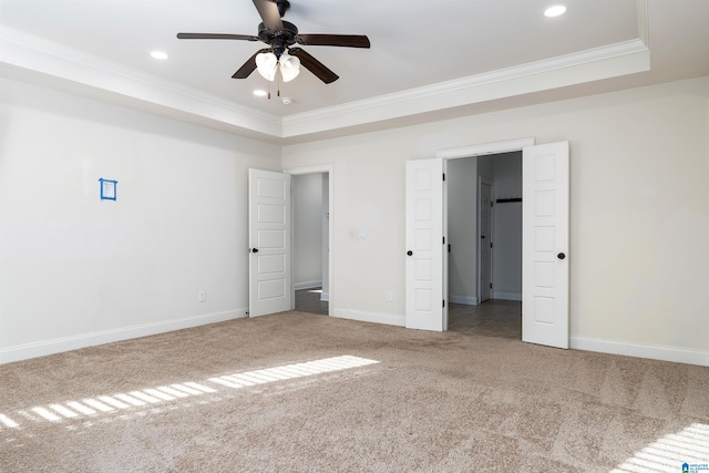 unfurnished bedroom with carpet floors, a raised ceiling, ceiling fan, and crown molding