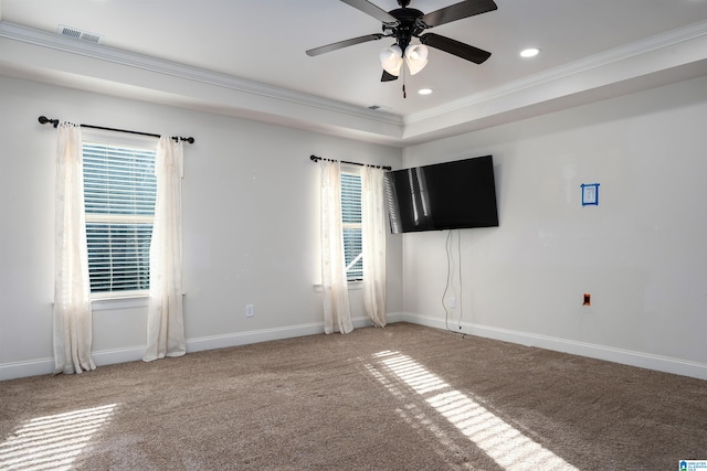 empty room with carpet, a raised ceiling, ceiling fan, and crown molding