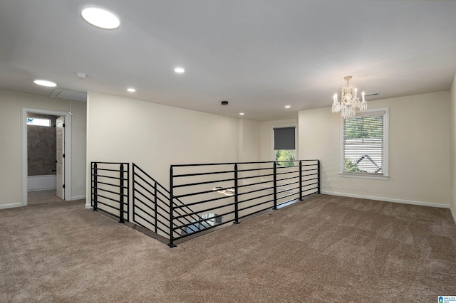 empty room featuring carpet floors and an inviting chandelier