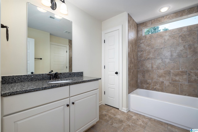 bathroom featuring vanity and tiled shower / bath combo