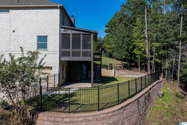 back of property with a patio, a lawn, and a sunroom