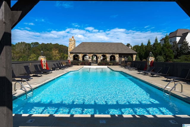 view of swimming pool featuring an outbuilding and a patio