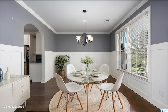 dining area with dark hardwood / wood-style flooring, a notable chandelier, and ornamental molding