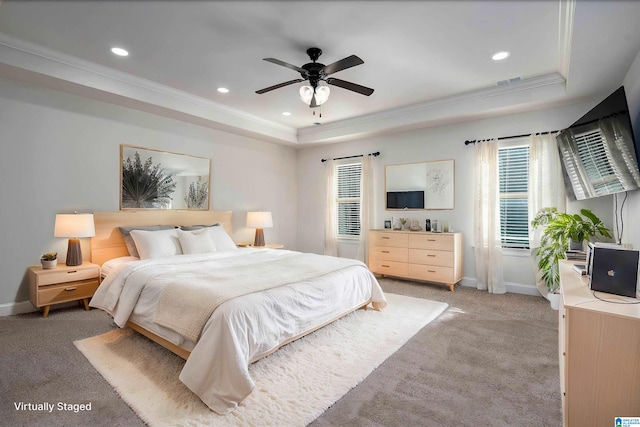 carpeted bedroom featuring ceiling fan, a raised ceiling, and crown molding