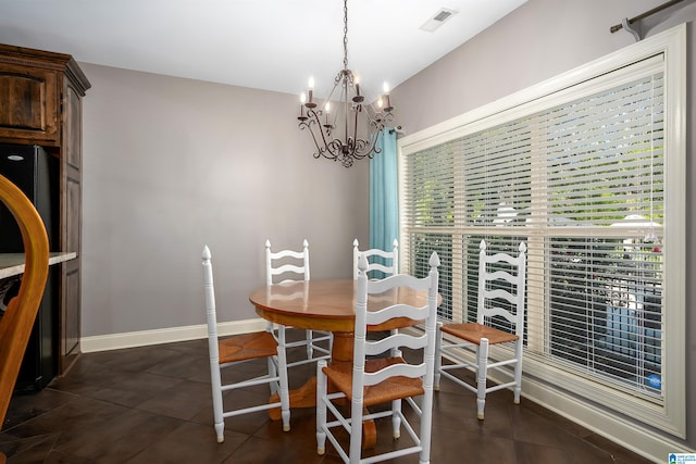 dining room with a notable chandelier and dark tile patterned floors