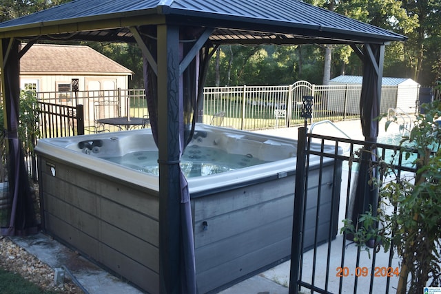 wooden deck featuring a hot tub and a gazebo