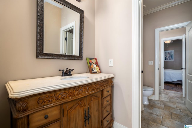 bathroom with vanity, crown molding, and toilet