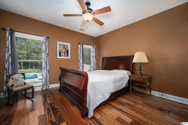 bedroom with dark hardwood / wood-style flooring and ceiling fan