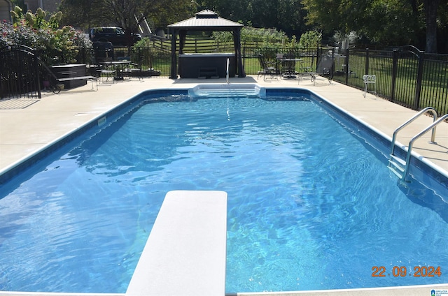 view of swimming pool featuring a gazebo, fence, a diving board, and a patio