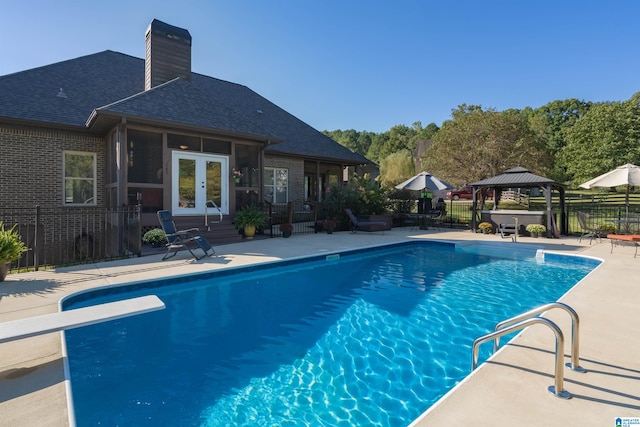 view of pool featuring a patio, a diving board, a gazebo, and french doors