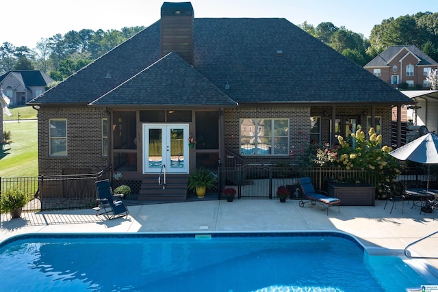 rear view of property featuring a patio, a fenced in pool, and french doors