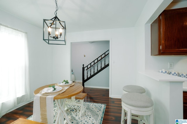 dining space with dark hardwood / wood-style floors and a chandelier