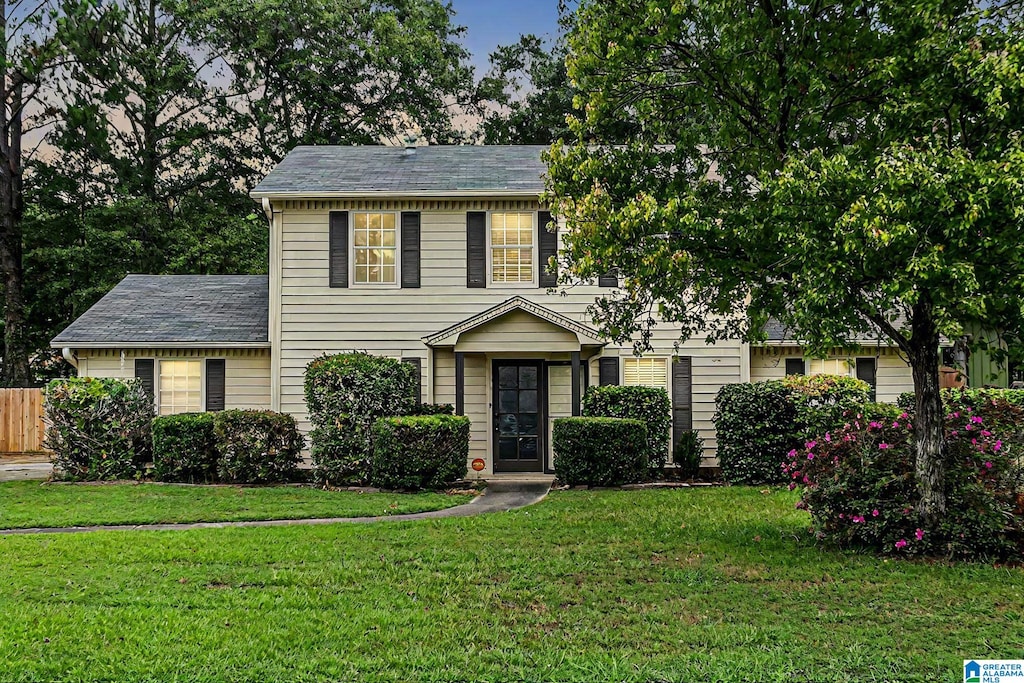 colonial house featuring a front lawn