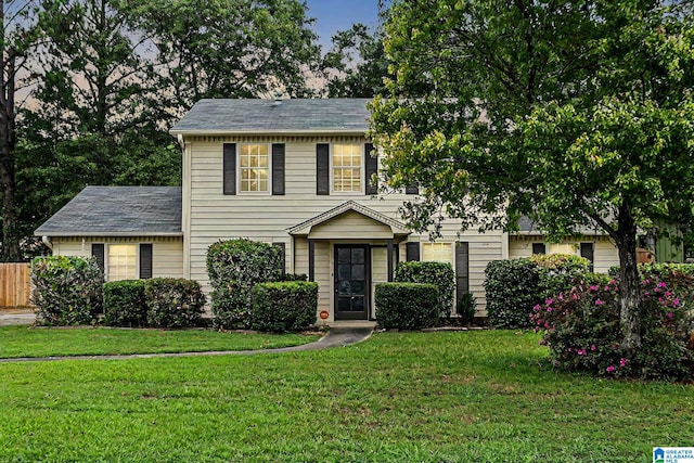 colonial house featuring a front lawn