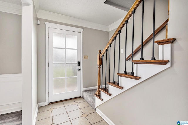 foyer entrance with a textured ceiling and crown molding