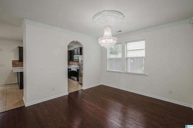 unfurnished dining area with hardwood / wood-style floors, a notable chandelier, and ornamental molding