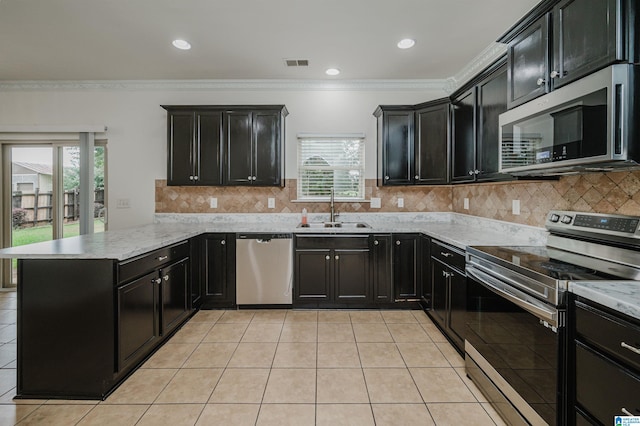 kitchen featuring sink, light tile patterned floors, stainless steel appliances, and kitchen peninsula