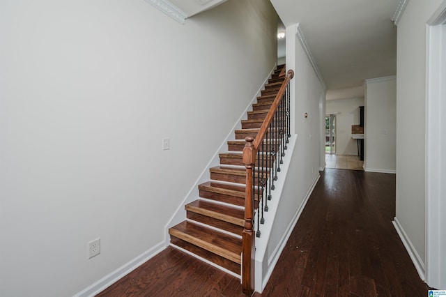 staircase with crown molding and wood-type flooring