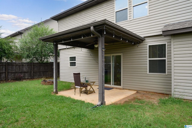 rear view of house featuring a yard, a patio area, and an outdoor fire pit