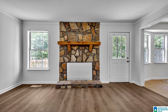 unfurnished living room featuring hardwood / wood-style floors, a healthy amount of sunlight, and crown molding