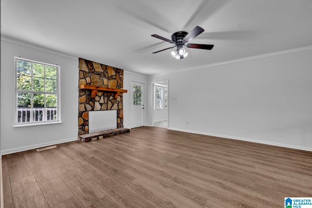 unfurnished living room featuring hardwood / wood-style flooring, ceiling fan, ornamental molding, and a fireplace