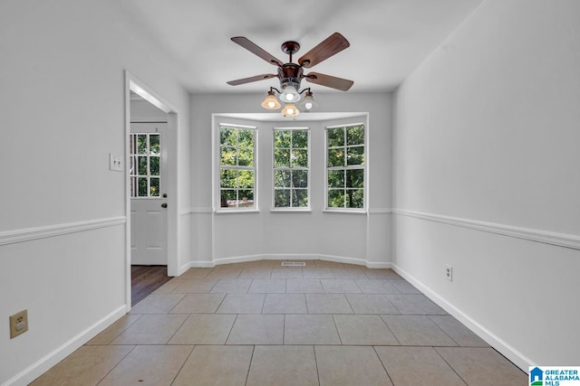 tiled spare room featuring ceiling fan