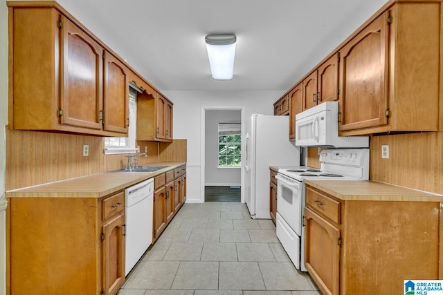 kitchen featuring white appliances, sink, and light tile patterned floors