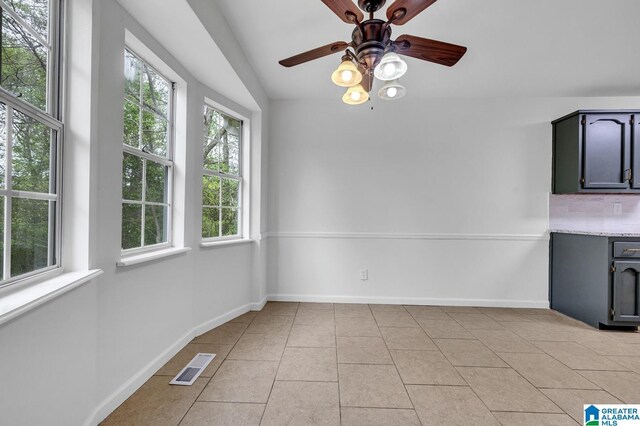 kitchen with a healthy amount of sunlight, white appliances, sink, and light tile patterned floors